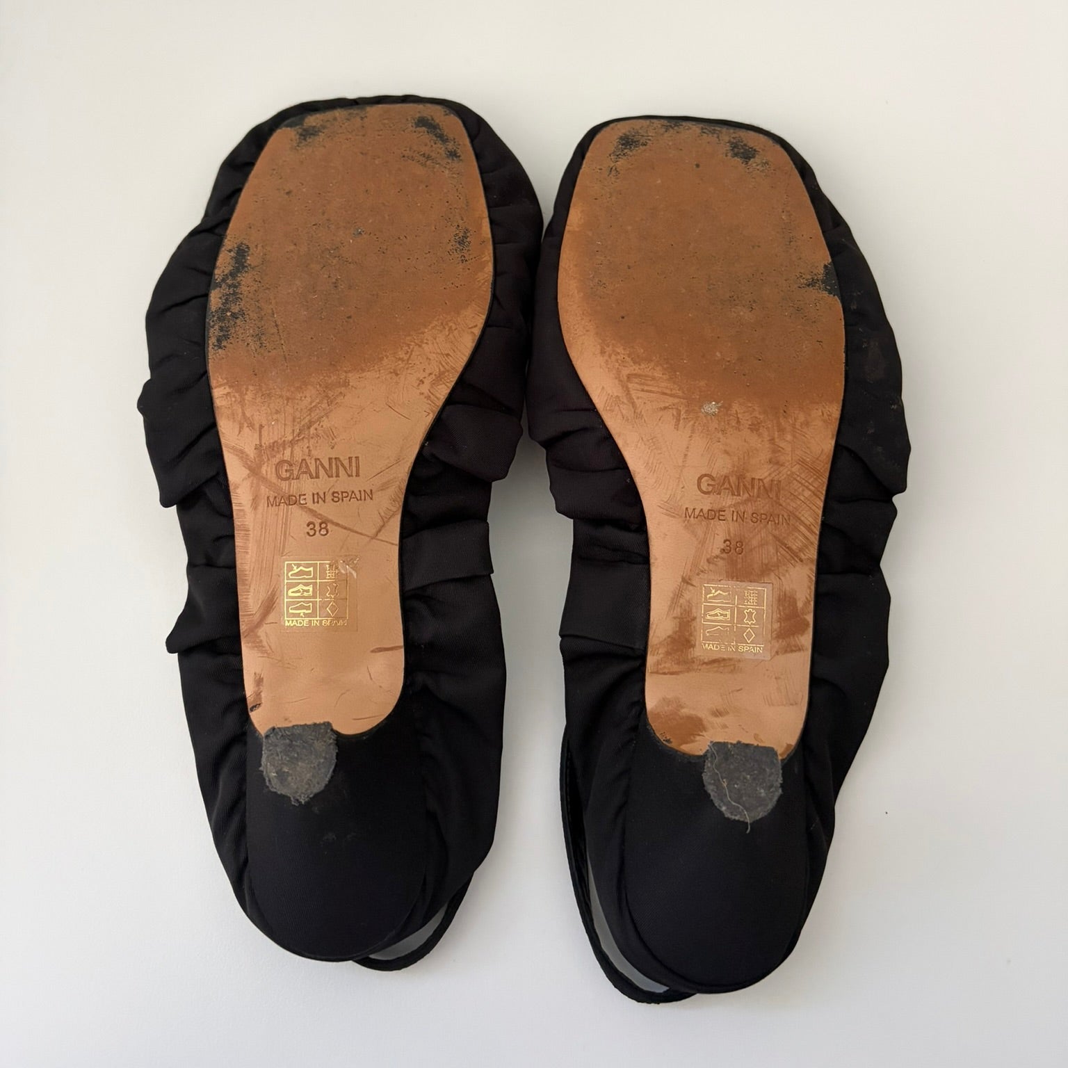 Black sandals with brown soles on a white background